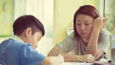 Mom helps boy with homework to help with executive function disorder.