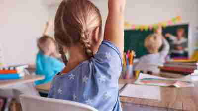 School children with ADHD raising their hands in class