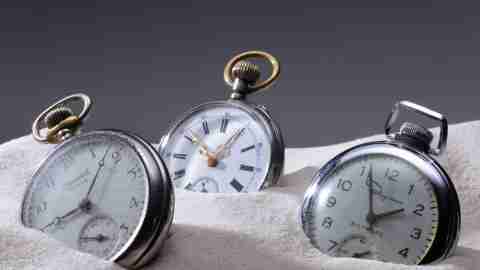 Three pocket watches in sand. People with impaired executive function need them to keep track of time.