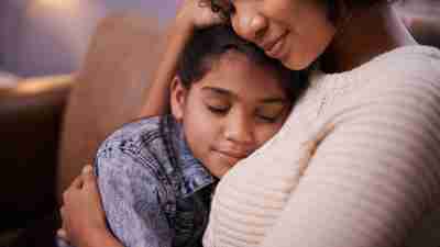 An overwhelmed mom relaxes for a minute to give her daughter a hug.