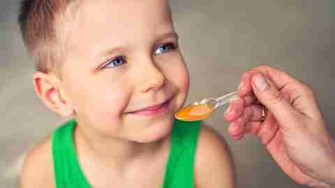 A child taking liquid ADHD medication, which has different side effects than traditional formulations