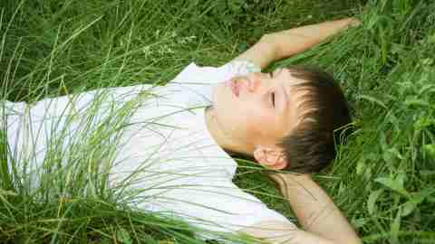 Boy laying on the grass as he ponders the side effects of his ADHD medication