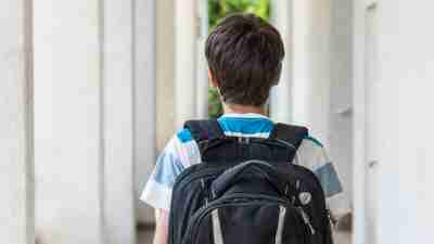 Teenage school boy with ADHD with a backpack walking to school