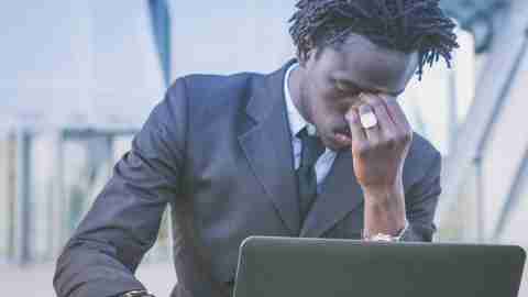 A man with anxious ADHD looks stressed out, anxious, and worried about something on his computer.