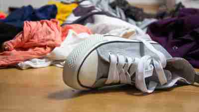 A messy floor covered in clothes that can't fit in a shared closet