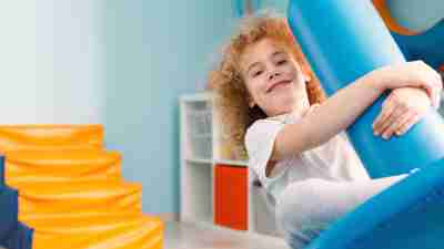 A happy boy with red hair using an occupational therapy disc at home to calm down