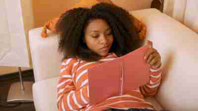 A high school girl writing in a pink planner