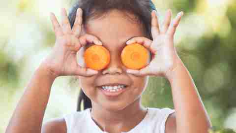 Cute asian child girl having fun to learn about vegetables with happiness