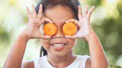 Cute asian child girl having fun to learn about vegetables with happiness