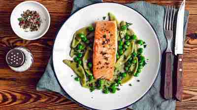 Baked salmon with garnish on wooden background