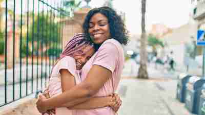 Black mother and daughter hugging. Self-compassion. Bonding.