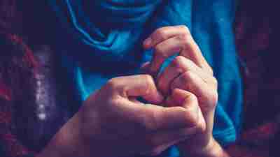 Close up on a young woman's hands as she is picking her nails