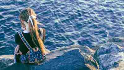 Little girl facing away from the camera and looking toward the water, symbolizing ADHD and emotional withdrawal in women