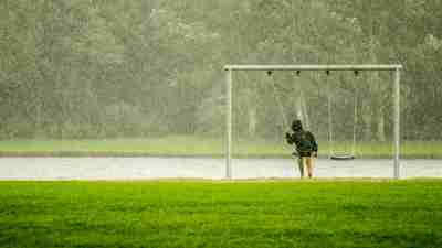 Boy swinging in the rain representing the isolation felt by many with ADHD