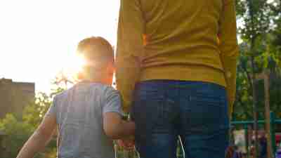 ADHD child holds his mother's hand as they go to the playground