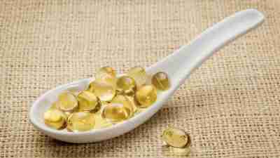 Spoon filled with fish oil capsules on burlap tablecloth, a good source of Omega 3 for people with ADHD