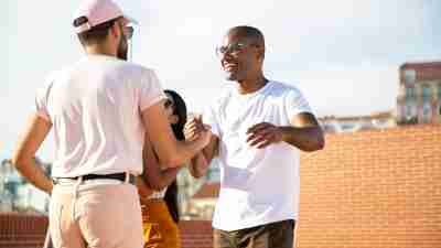 Two adult men shake hands, joyfully, exhibiting how to make friends with ADHD.