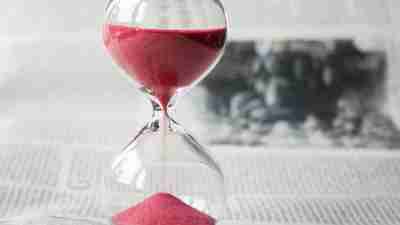 Glass hour glass with red sand, demonstrating ADHD challenges with time management and punctuality.