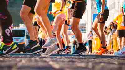 A group of runners bounce at the startline of a race, readying to run a race -- a great way to start working out.