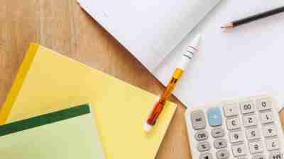 ADHD student's notebooks, calculator and pen on wooden table