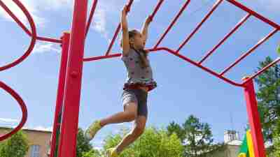 An impulsive little girl on a jungle gym