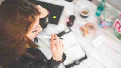 A photo of a woman at work nervously looking at her planner